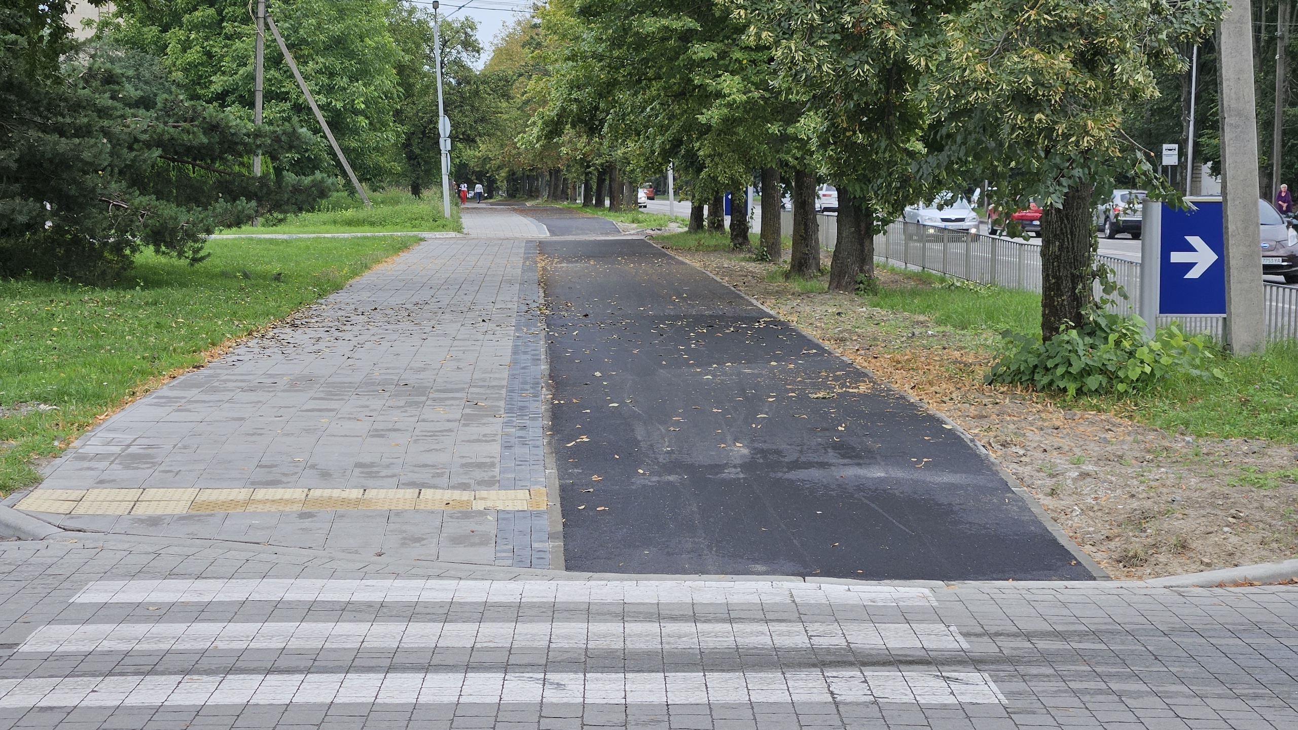 Розмітка пішохідного переходу, а за нею — суміжні пішохідна та велосипедна доріжки