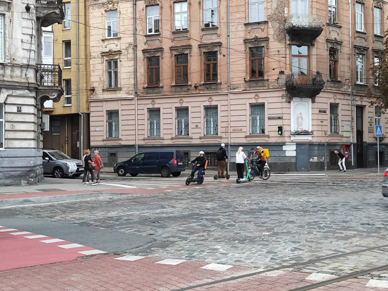 Самокати і велосипедисти їдуть велопереїздом на площі Лема